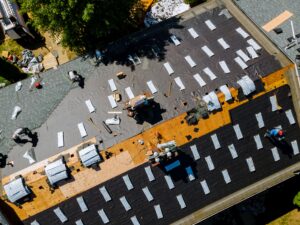 a photo of roof replacement, prompting the question "Can a roof be replaced in the rain?"